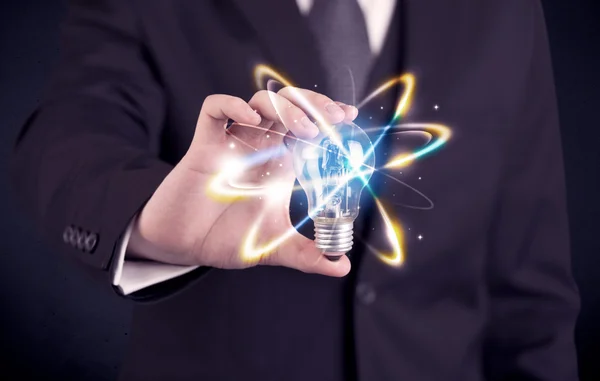 Businessman holding a colorful light bulb — Stock Photo, Image