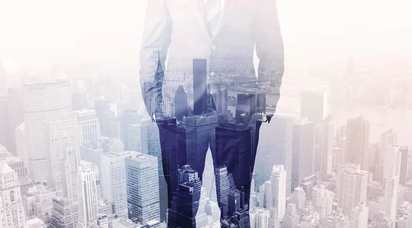 Business man standing on roof with city in the background — Stock Photo, Image