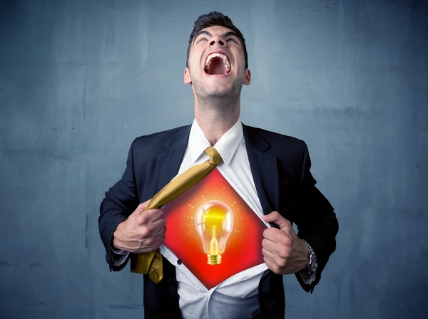 Businessman ripping off shirt and idea light bulb appears — Stock Photo, Image