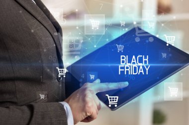 Genç adam tabletle alışveriş yapıyor.