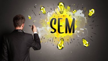 Adam renkli ampul çiziyor.