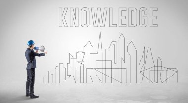 Kasketli bir iş adamı elinde planlar tutuyor