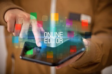 Katlanabilir akıllı telefon tutan genç adam.