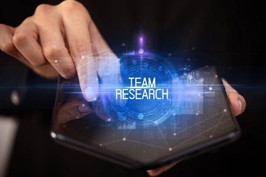 Katlanabilir akıllı telefon tutan genç adam.