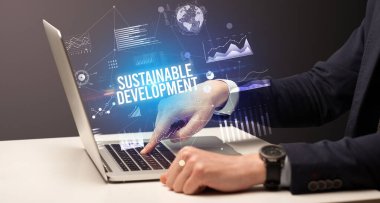 Dizüstü bilgisayar ve iş konsepti üzerinde çalışan iş adamı