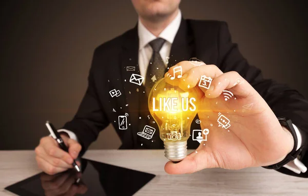 Businessman holding a light bulb, social media concept — Stock Photo, Image