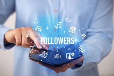 Katlanabilir akıllı telefonu olan bir iş adamı, sosyal medya kavramı