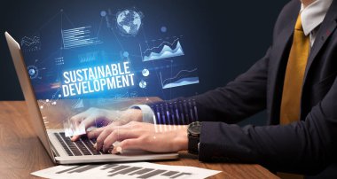 Dizüstü bilgisayar ve iş konsepti üzerinde çalışan iş adamı