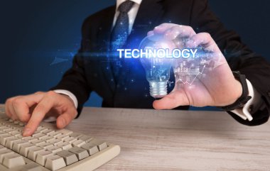 Elinde ampul tutan bir iş adamı.