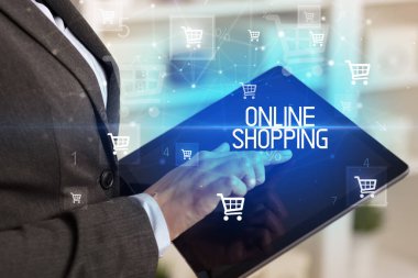 Genç adam tabletle alışveriş yapıyor.