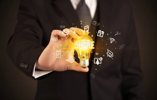 Businessman holding a light bulb, social media concept — Stock Photo, Image