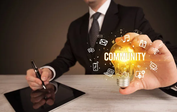 Businessman holding a light bulb, social media concept — Stock Photo, Image