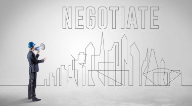 Kasketli bir iş adamı elinde planlar tutuyor