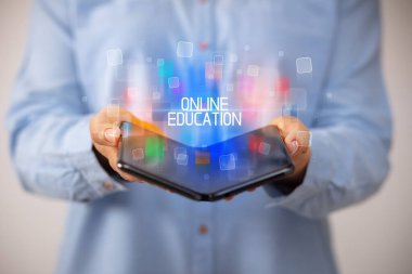 Katlanabilir akıllı telefon tutan genç adam.