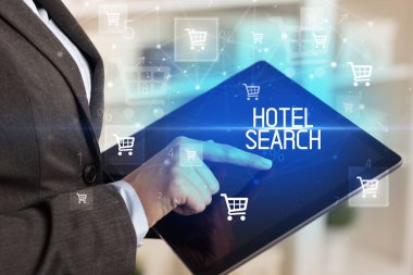 Genç adam tabletle alışveriş yapıyor.