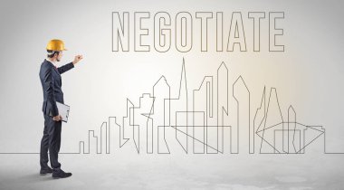 Kasketli bir iş adamı elinde planlar tutuyor