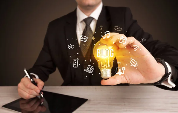 Businessman holding a light bulb, social media concept — Stock Photo, Image