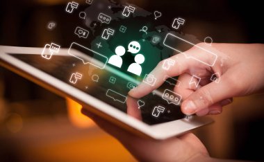 Tablet, sosyal medya kavramı kullanan bir elin yakın plan çekimi