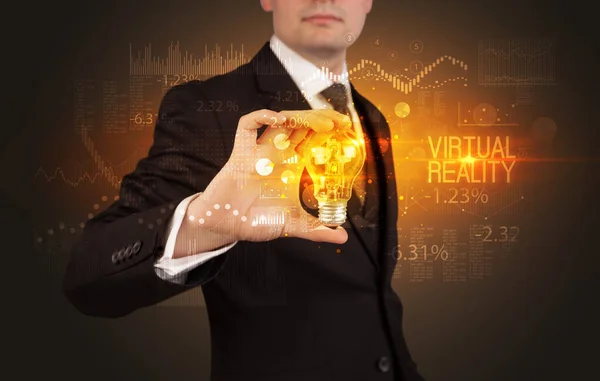 Businessman holding a lightbulb concept — Stockfoto