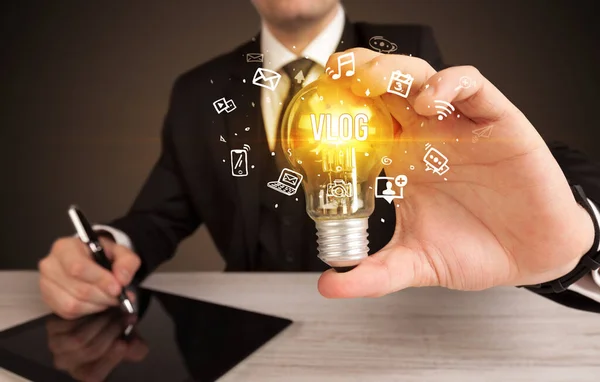 Businessman holding a light bulb, social media concept — Stock Photo, Image