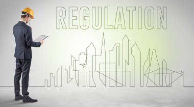 Kasketli bir iş adamı elinde planlar tutuyor