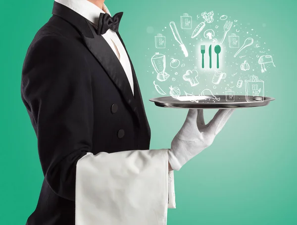 Waiter holding silver tray with food icons above — Stock Photo, Image