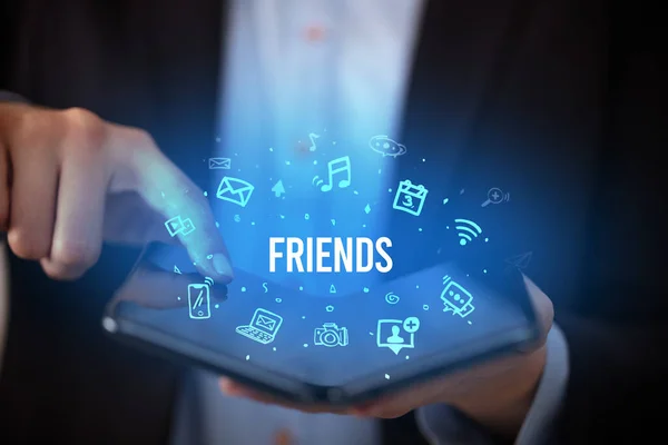 Üzletember kezében egy összecsukható okostelefon, szociális média koncepció — Stock Fotó