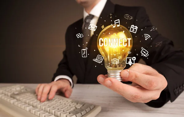 Businessman holding a light bulb, social media concept — Stock Photo, Image