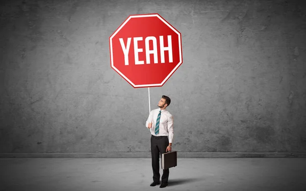 Young business person holding road sign — Stock Photo, Image