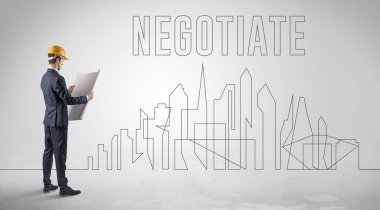 Kasketli bir iş adamı elinde planlar tutuyor