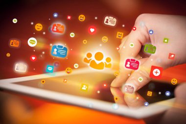 Sosyal medya simgelerine sahip tablet kullanan bir elin yakın plan görüntüsü