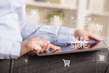 Genç adam tabletle alışveriş yapıyor.