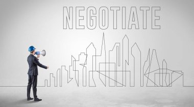 Kasketli bir iş adamı elinde planlar tutuyor