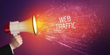 Genç bir kadın hoparlöre bağırıyor.