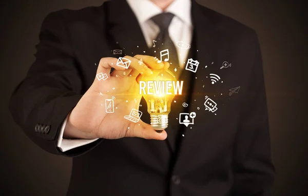 Businessman holding a light bulb, social media concept — Stock Photo, Image