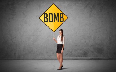 Genç iş adamı yol tabelasını tutuyor.