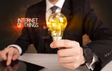 Elinde ampul tutan bir iş adamı.