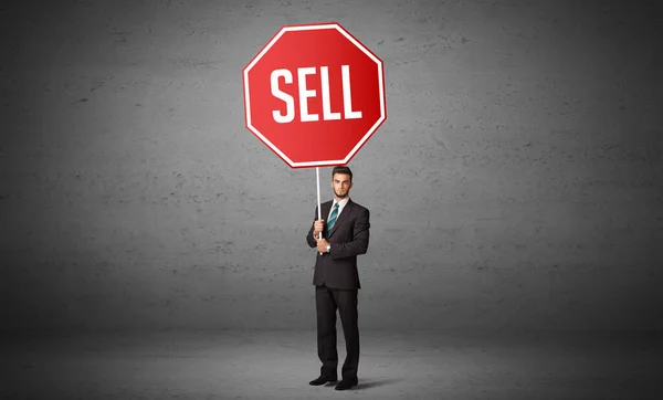 Young business person holding road sign — Stock Photo, Image