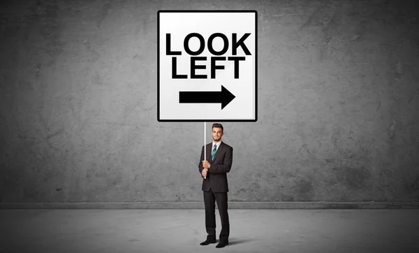 Business person holding a traffic sign — Stock Photo, Image