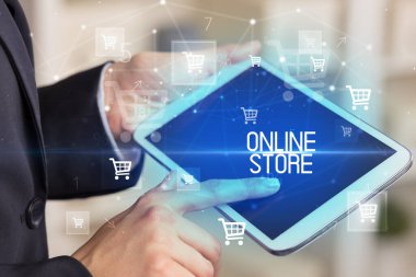 Genç adam tabletle alışveriş yapıyor.