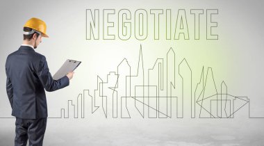 Kasketli bir iş adamı elinde planlar tutuyor