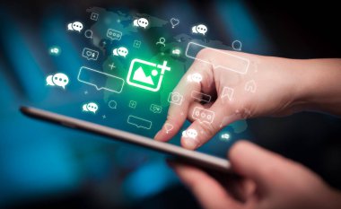 Tablet, sosyal medya kavramı kullanan bir elin yakın plan çekimi