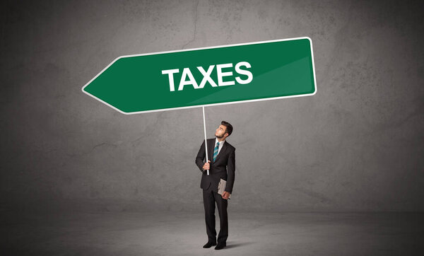 Молодой бизнесмен в случайном держании дорожного знака