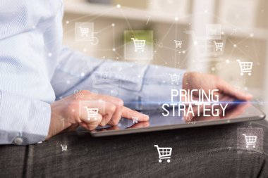 Genç adam tabletle alışveriş yapıyor.