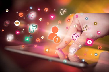Sosyal medya simgelerine sahip tablet kullanan bir elin yakın plan görüntüsü