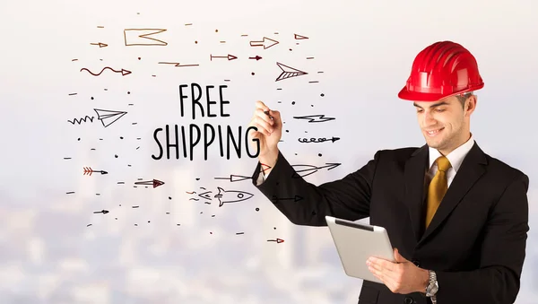 Young businessman with helmet drawing sale sign — Stock Photo, Image