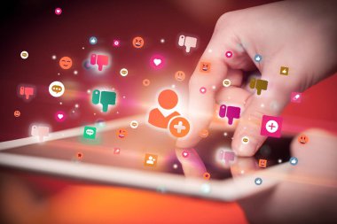 Sosyal medya simgelerine sahip tablet kullanan bir elin yakın plan görüntüsü