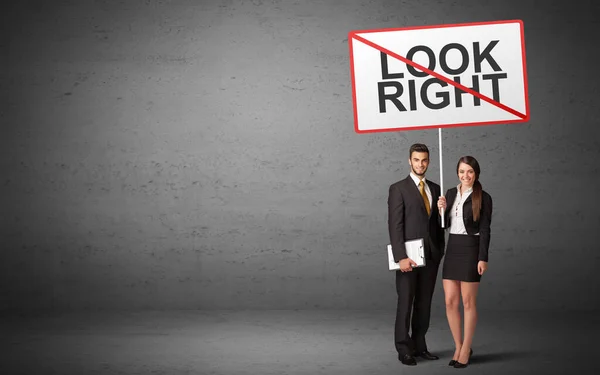 Business person holding a traffic sign — Stock Photo, Image