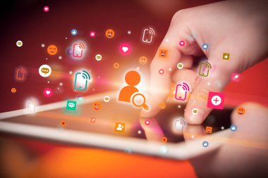 Sosyal medya simgelerine sahip tablet kullanan bir elin yakın plan görüntüsü
