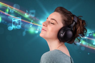 Kulaklıkla müzik dinleyen genç bir kadın.